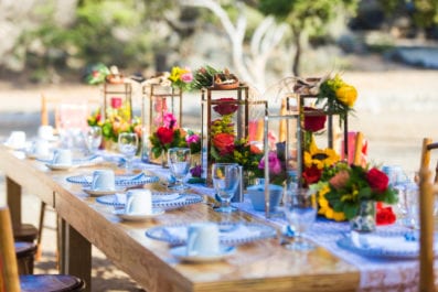 long wooden table and chairs setup with colorful flower decoration for breakfast at Ayo rock formations